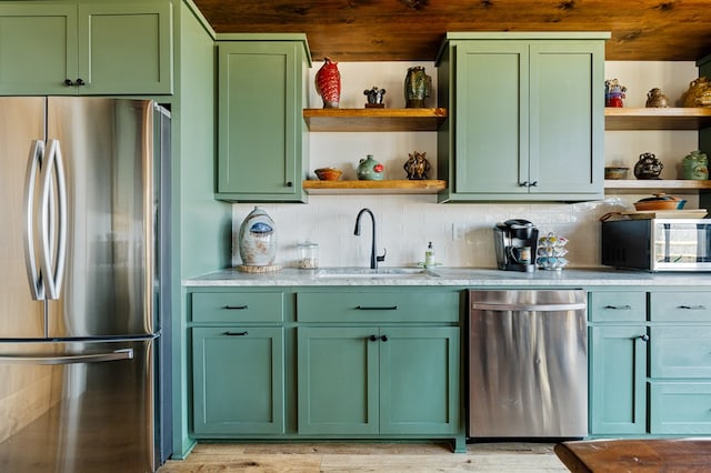 kitchen with open shelves, green cabinets, stainless steel appliances, and a sink