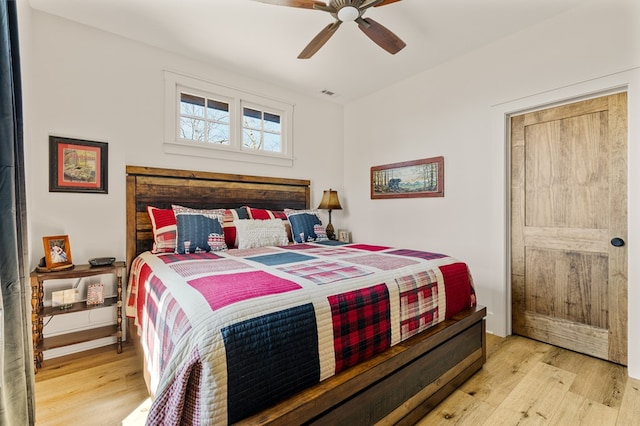 bedroom with a ceiling fan, visible vents, and light wood-style flooring