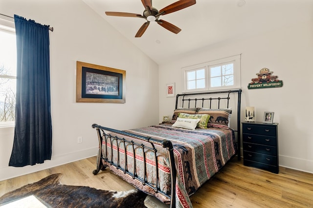 bedroom with ceiling fan, vaulted ceiling, baseboards, and wood finished floors