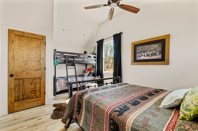 bedroom with a ceiling fan, lofted ceiling, and wood finished floors