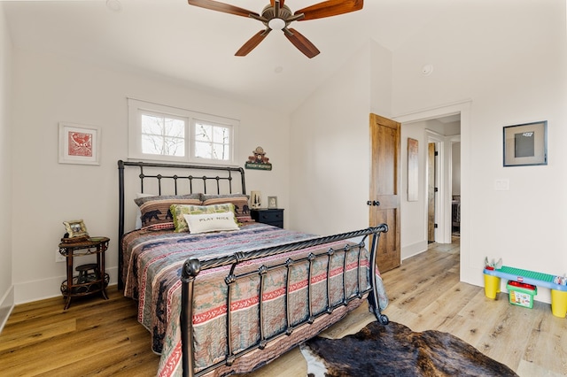 bedroom with light wood-type flooring, lofted ceiling, ceiling fan, and baseboards