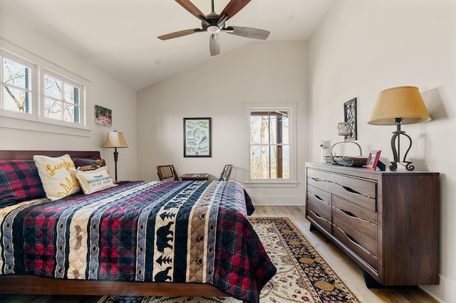 bedroom featuring lofted ceiling, light wood-style flooring, and a ceiling fan