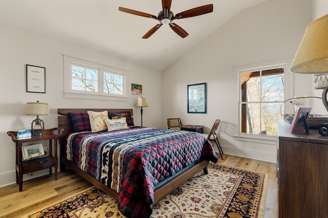 bedroom featuring lofted ceiling, light wood finished floors, baseboards, and a ceiling fan