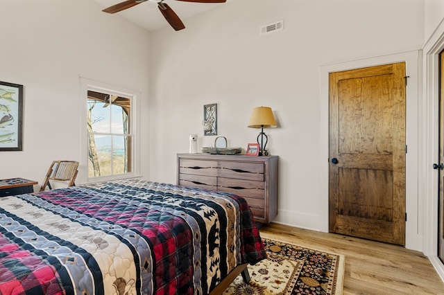 bedroom featuring high vaulted ceiling, visible vents, ceiling fan, and wood finished floors