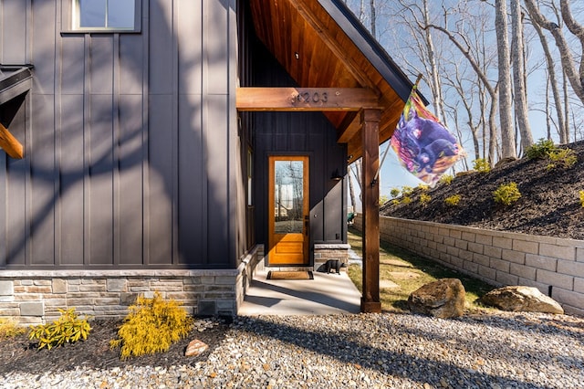 entrance to property with stone siding and board and batten siding