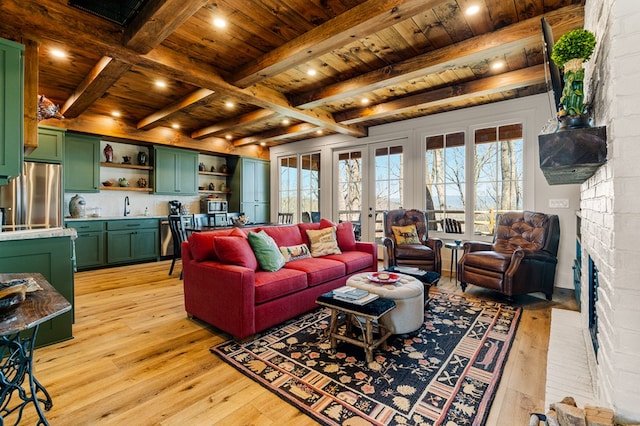 living room with light wood-type flooring, a brick fireplace, wooden ceiling, and beamed ceiling