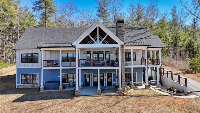 back of house with a patio, board and batten siding, a balcony, and a jacuzzi