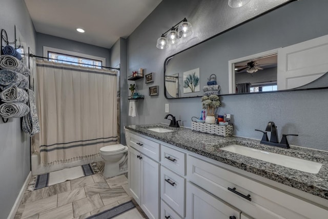 full bath with double vanity, shower / bath combo, a sink, and toilet