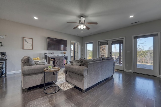 living area featuring baseboards, french doors, dark wood-style flooring, and a healthy amount of sunlight