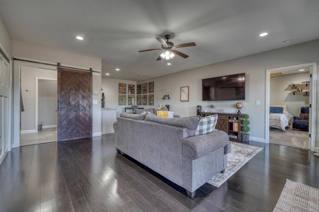 living room with dark wood finished floors, recessed lighting, a barn door, a ceiling fan, and baseboards