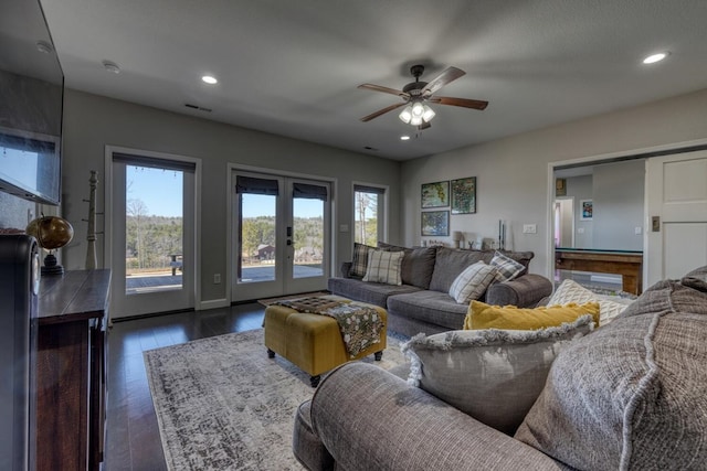 living area with dark wood-type flooring, a wealth of natural light, french doors, and visible vents