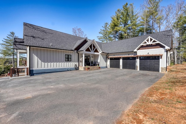 modern farmhouse featuring board and batten siding, roof with shingles, driveway, and an attached garage