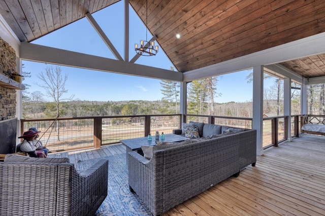 wooden terrace with outdoor lounge area and a forest view