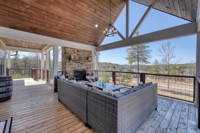 deck with an outdoor living space with a fireplace