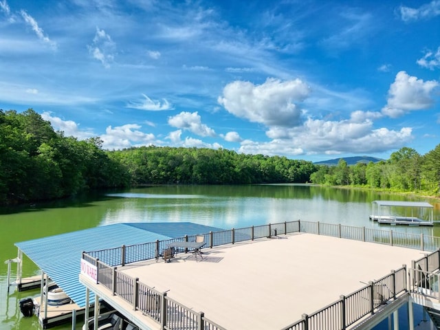 view of dock featuring a water view and a forest view