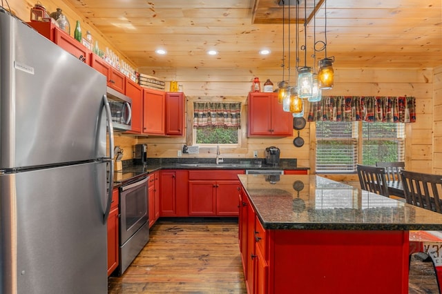 kitchen featuring wood ceiling, wood-type flooring, wooden walls, a kitchen island, and stainless steel appliances