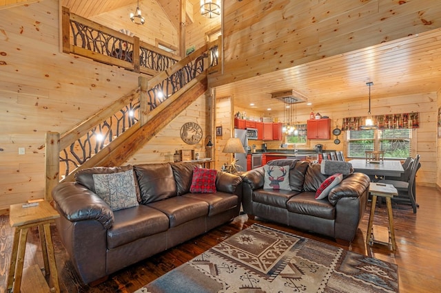 living room with wooden walls, high vaulted ceiling, and hardwood / wood-style floors