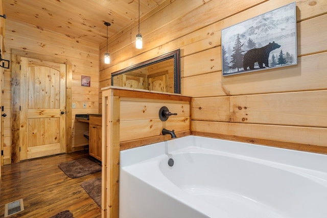 bathroom featuring wood walls, hardwood / wood-style floors, wooden ceiling, and a tub to relax in