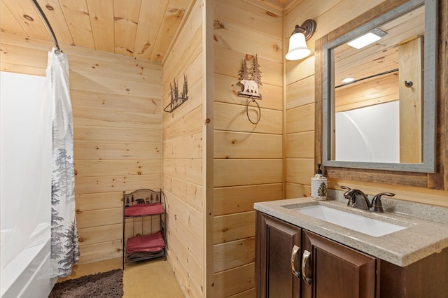 bathroom with wood walls, wooden ceiling, shower / bath combo with shower curtain, and vanity