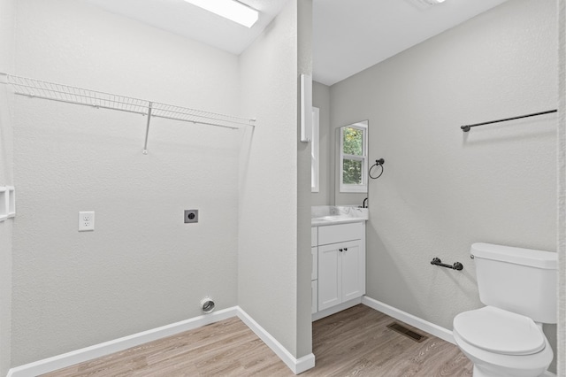 interior space with hardwood / wood-style floors, vanity, and toilet