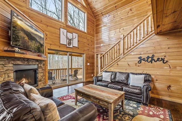 living room featuring wood ceiling, hardwood / wood-style flooring, high vaulted ceiling, a fireplace, and wood walls