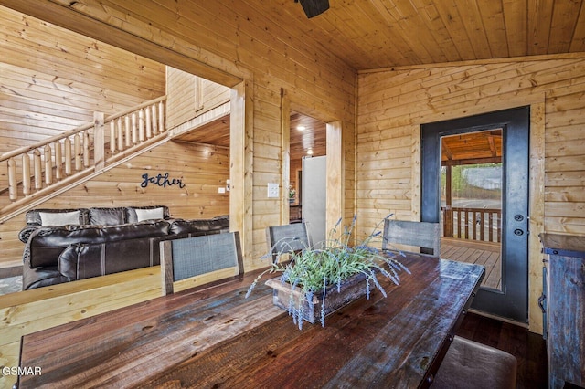 dining room featuring wood walls, wooden ceiling, lofted ceiling, and wood-type flooring