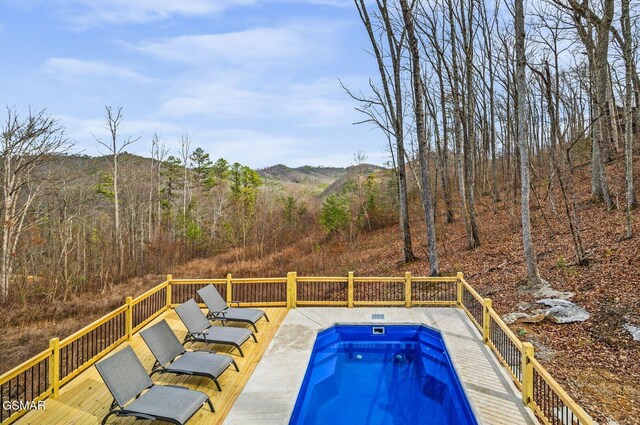 view of pool featuring a wooden deck and a hot tub