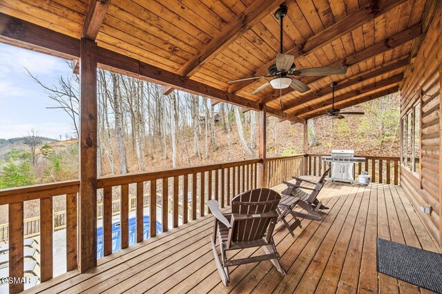 wooden deck featuring grilling area, ceiling fan, and a swimming pool