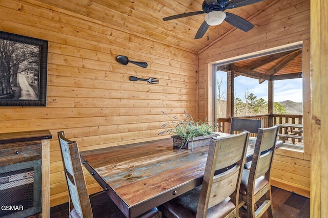 dining space featuring wooden walls, wooden ceiling, ceiling fan, and lofted ceiling