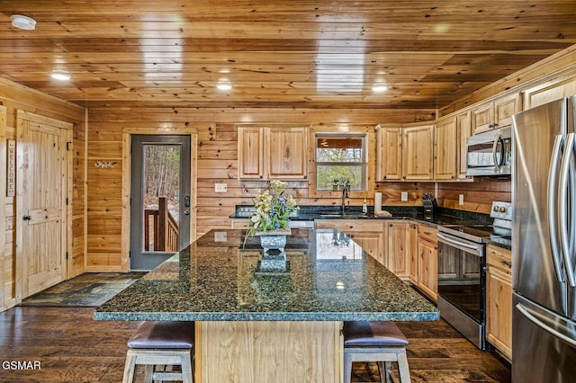 kitchen featuring a kitchen bar, a kitchen island, and appliances with stainless steel finishes