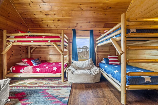 bedroom with hardwood / wood-style floors, wood ceiling, wooden walls, and vaulted ceiling