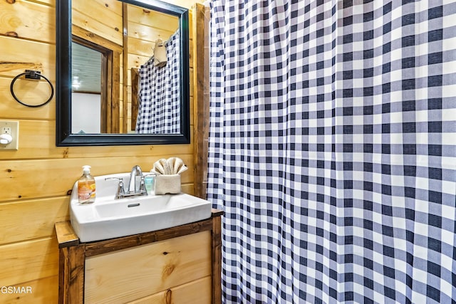 bathroom with vanity and wooden walls