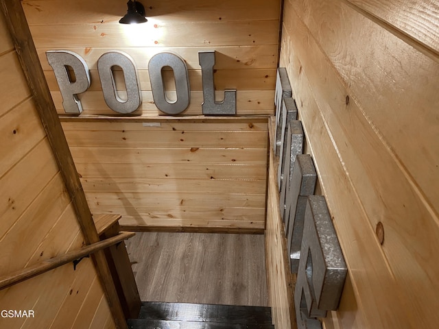 interior space with hardwood / wood-style flooring and wood walls