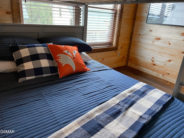 bedroom featuring wooden walls and dark hardwood / wood-style flooring