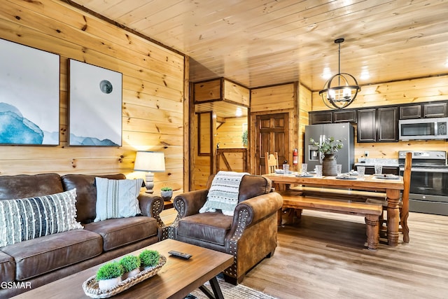 living room with wood ceiling, wood walls, light wood-type flooring, and a notable chandelier