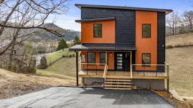 contemporary home featuring metal roof, covered porch, and a mountain view