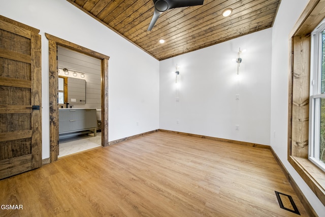 empty room featuring light wood-type flooring, baseboards, wood ceiling, and vaulted ceiling