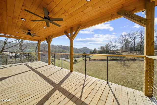 wooden deck with a mountain view and a ceiling fan