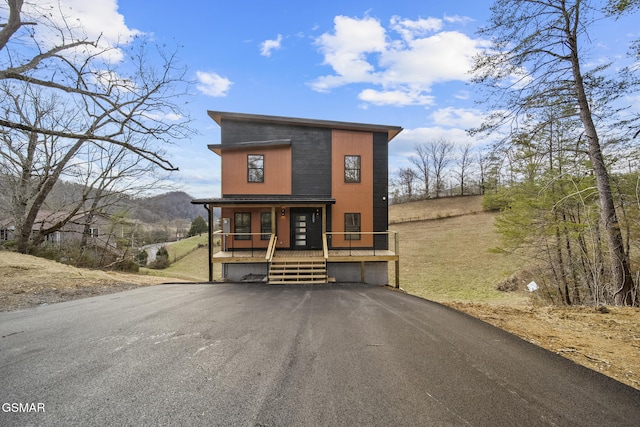 contemporary house with a porch, an attached garage, and driveway