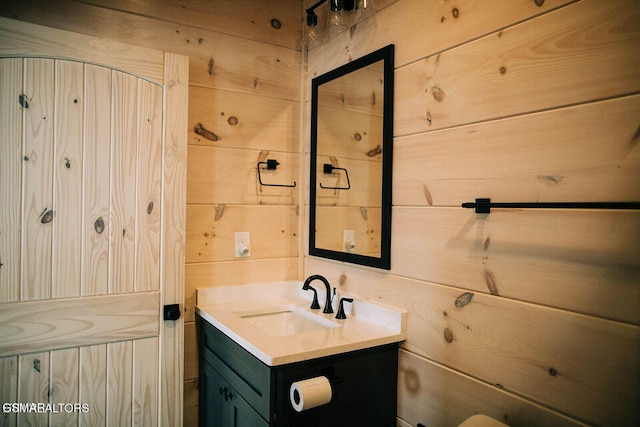 bathroom with vanity and wood walls