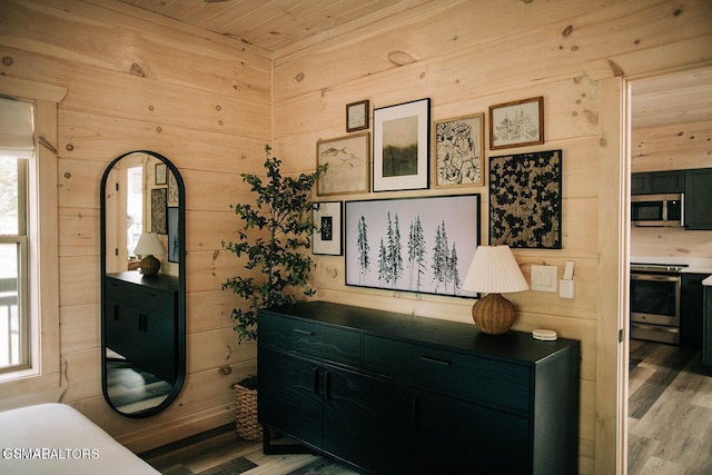 details featuring wooden walls and appliances with stainless steel finishes