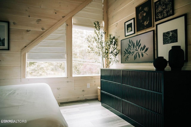 bedroom featuring wood-type flooring and wooden walls