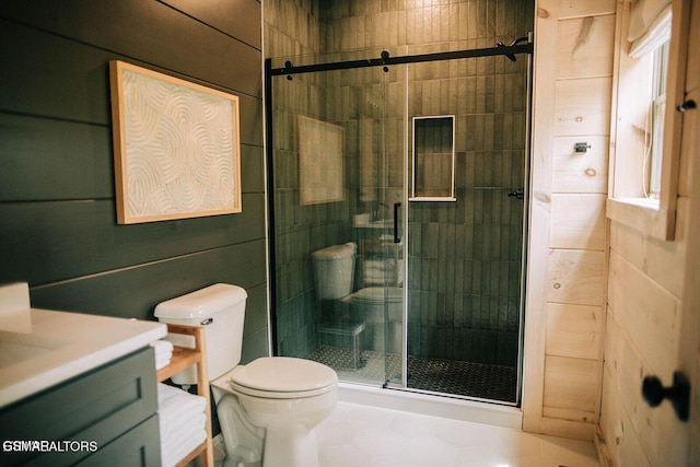 bathroom featuring vanity, a shower with shower door, and toilet