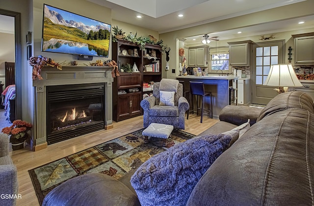 2846 Mountain View Cir, Sevierville, TN 37862 - living area featuring a glass covered fireplace, light wood finished floors, recessed lighting, and crown molding