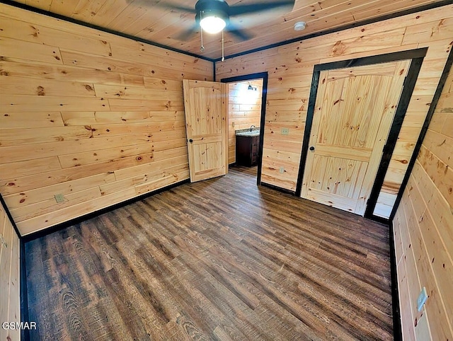 unfurnished bedroom with dark hardwood / wood-style floors, ceiling fan, wooden walls, and wood ceiling