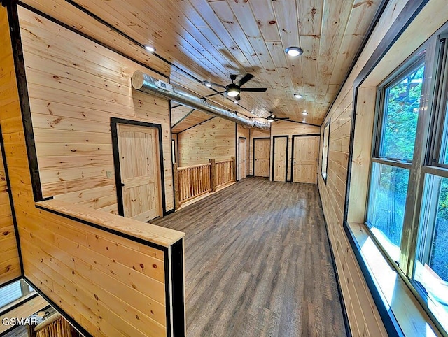 hallway with dark hardwood / wood-style flooring, wooden walls, and wood ceiling