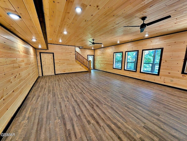 interior space featuring wooden walls, dark hardwood / wood-style flooring, ceiling fan, and wooden ceiling