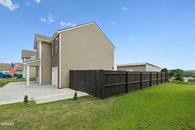 view of side of property featuring a lawn and a garage