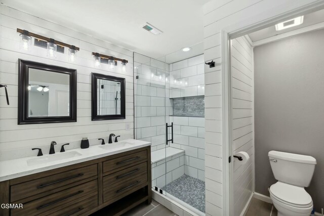 bathroom featuring tile patterned flooring, vanity, toilet, and an enclosed shower