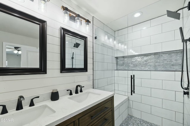 bathroom with vanity, ceiling fan, and tiled shower